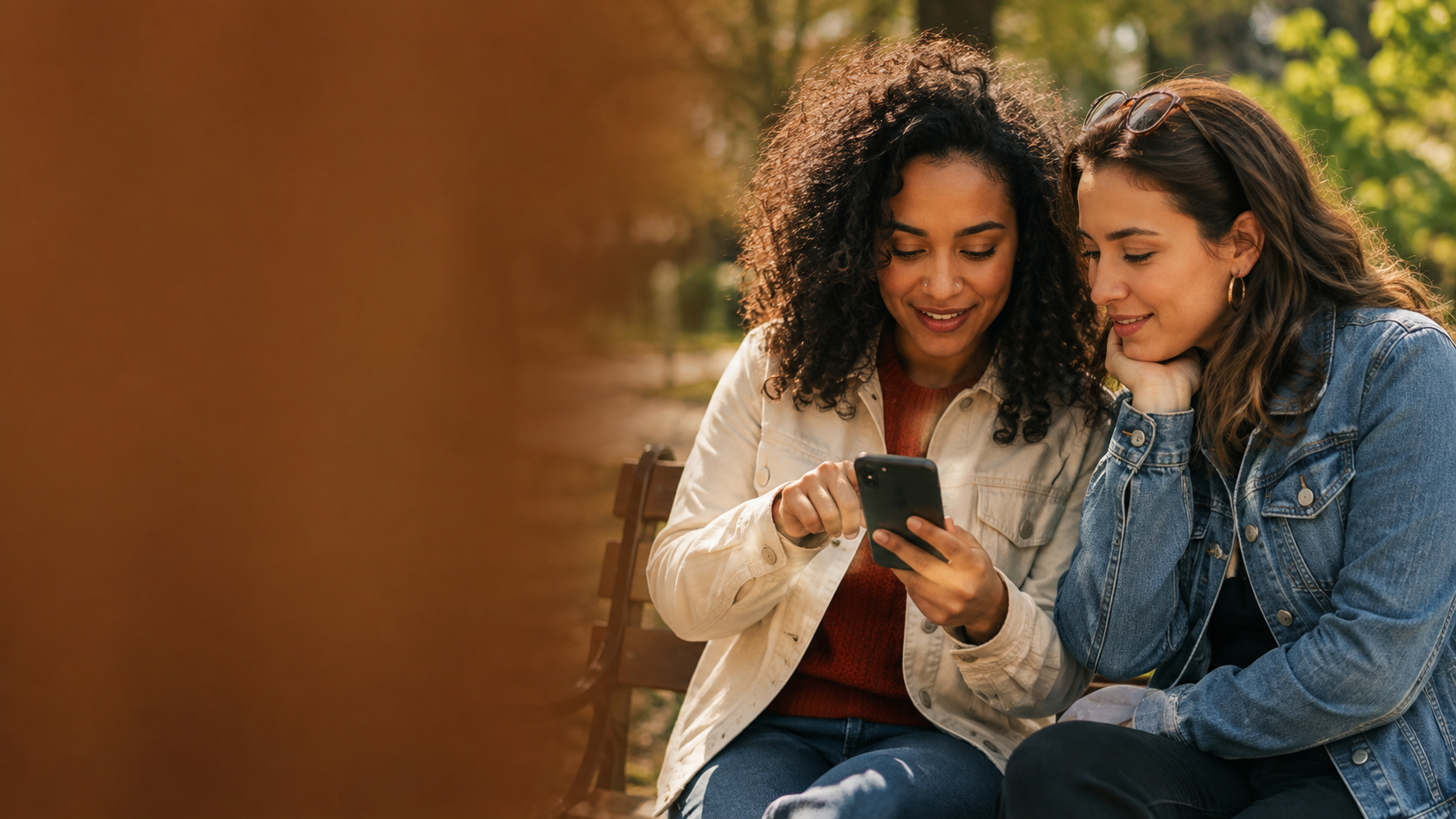 Two friends exploring services on a phone together on a park bench