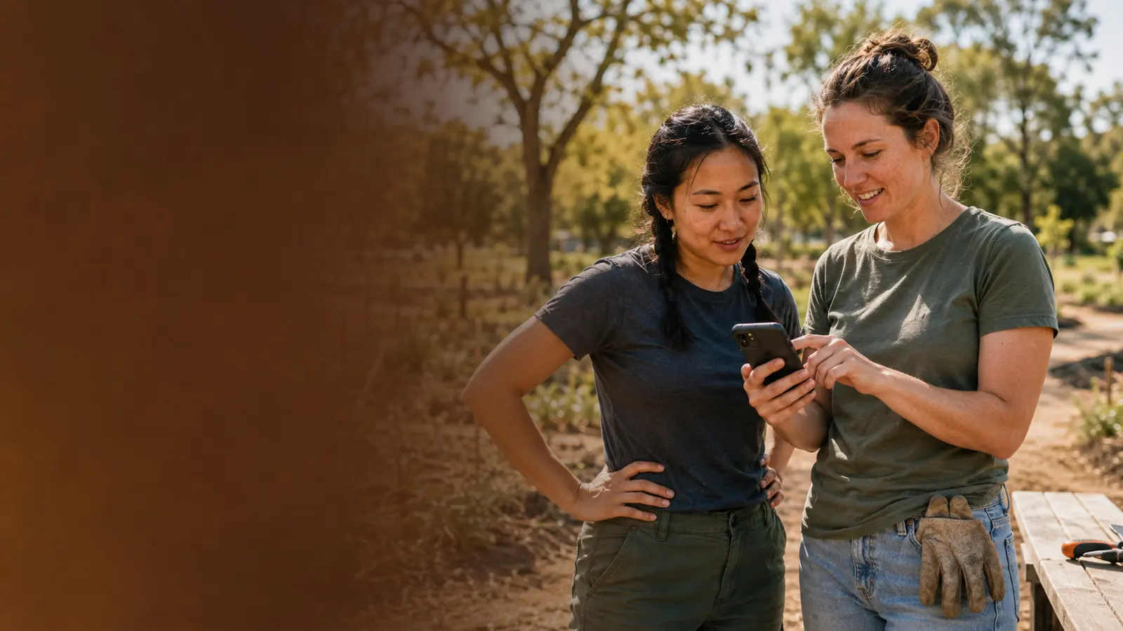 Two volunteers checking a phone in a community garden